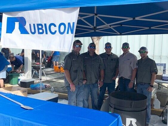 Cooking for a Good Cause, Rubicon employees standing next to large branded cooking pot